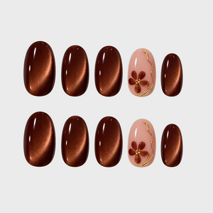 Brown cat eye press-on nails featuring a floral design on a pink base.