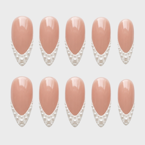 A set of nude press-on nails with white pearl French tips.