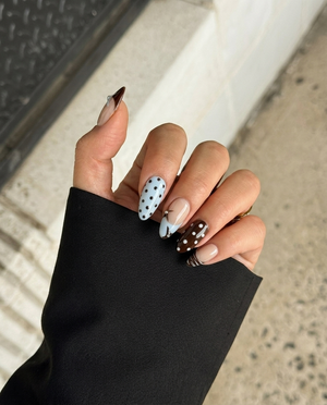 Glossy brown and light blue press-on nails with star motifs, polka dots, and rhinestone accents.