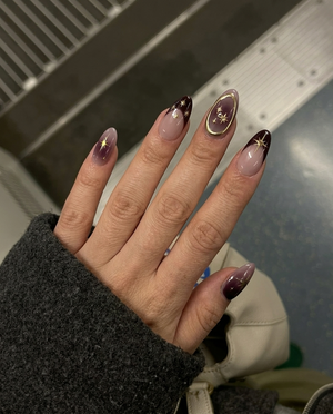 Celestial burgundy French press-on nails with gold star and constellation designs.