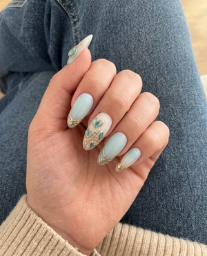 Mint blue and milky white ombr������������ press-on nails with 3D heart-shaped floral details and metallic gold accents.