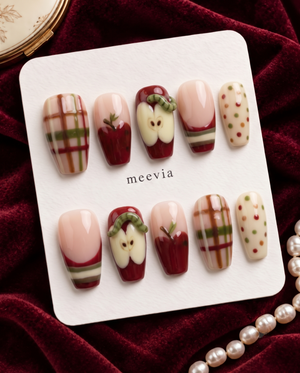 Apple-themed press-on nails with red apples, plaid stripes, cream accents, and colorful dots