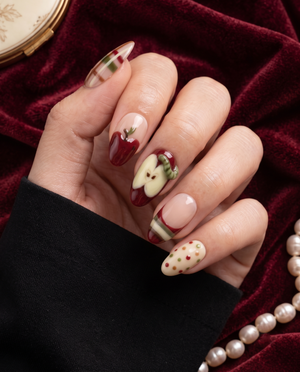 Apple-themed press-on nails with red apples, plaid stripes, cream accents, and colorful dots