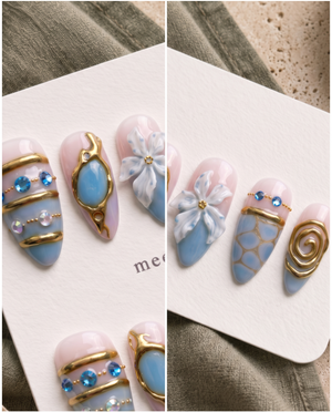 Blue and gold floral embellished press-on nails with glossy pink and blue details, gems, beads, and raised flower accents