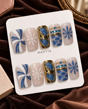 Blue and gold chrome snowflake press-on nails with glitter and rhinestone details
