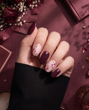 Burgundy and pink floral press-on nails with glossy finish and gold glitter accents