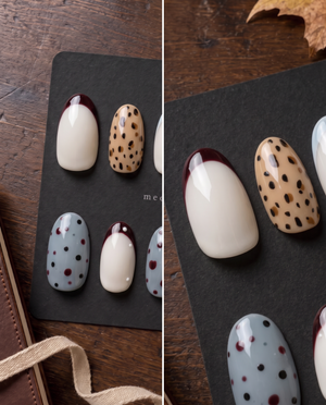 Glossy press-on nails with burgundy French tips, tan leopard print, creamy white bases, and blue dotted accents