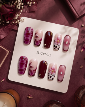 Burgundy and pink floral cow print press-on nails with glossy finish and gold embellishments