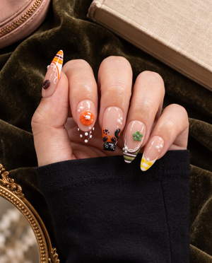 Glossy pink press-on nails with cat, dessert, flower, pearl, and gingham motifs