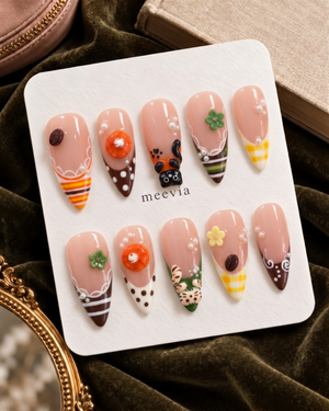 Glossy pink press-on nails with cat, dessert, flower, pearl, and gingham motifs