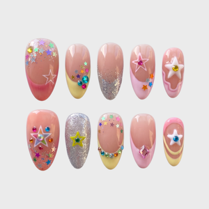 A set of pastel press-on nails featuring colorful star charms, rhinestone accents, and glitter French tips.