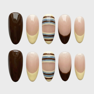 A set of press-on nails featuring mocha brown, cream, and blue striped designs with French tips.