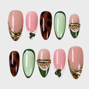 Set of press-on nails featuring olive green, pink, and tortoise shell patterns with gold foil and bead embellishments.