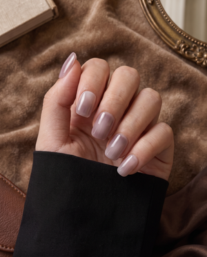 Glossy mauve taupe almond press-on nails displayed on a black nail card