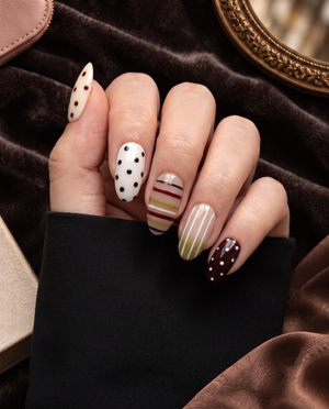 Mixed-pattern neutral press-on nails with olive, cream, nude, burgundy, black stripes and polka dots
