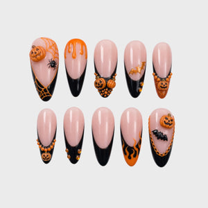 Halloween themed press-on nails with black French tips, 3D pumpkins, bat charms, flames, and spider web designs.