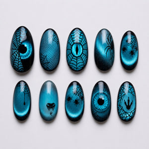 Teal cat-eye press-on nails with black spiderwebs, spiders, snake motif, claw marks, and reptile eye designs.