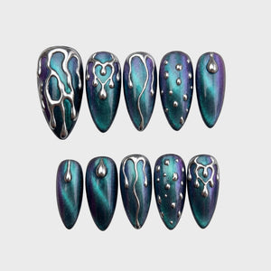 Set of press-on nails featuring teal and purple cat-eye polish with silver 3D chrome drip and droplet designs.