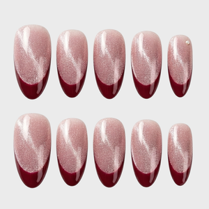 Burgundy cat eye French tip press-on nails with a single pearl accent.