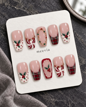 Pink Christmas press-on nails with plaid tips, holly berries, peppermint swirls, and glossy finish
