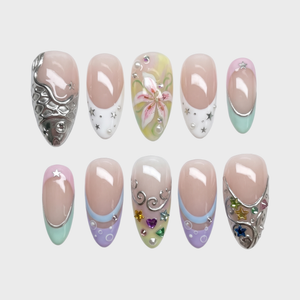 Pastel mermaid press-on nails featuring silver metallic fish scales, colorful star gems, and a pink lily flower design.