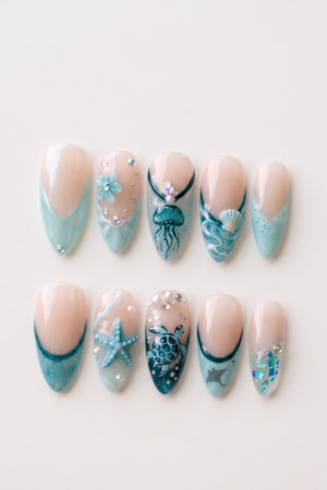 A set of teal-toned press-on nails featuring ocean motifs like a starfish, jellyfish, seashell, and sea turtle with rhinestone accents.