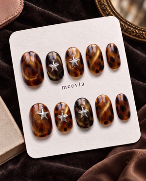 Tortoise-shell cat-eye press-on nails with raised silver star embellishments