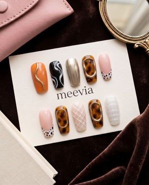 Tortoiseshell and abstract art press-on nails with pink, gold, orange, black, and white designs