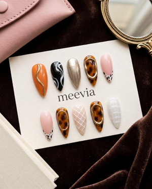 Tortoiseshell and abstract art press-on nails with pink, gold, orange, black, and white designs