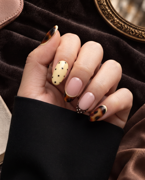Tortoiseshell, pink French, and yellow polka dot press-on nails displayed on a white card