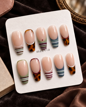 Nude press-on nails with tortoiseshell French tips and multicolor striped designs