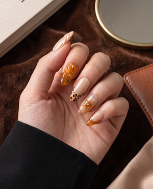 Nude and amber tortoiseshell swirl French tip press-on nails with spotted and rhinestone accents