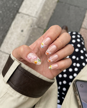 A set of nude French tip press-on nails decorated with 3D colorful fish, green seaweed, and clear water bubbles.