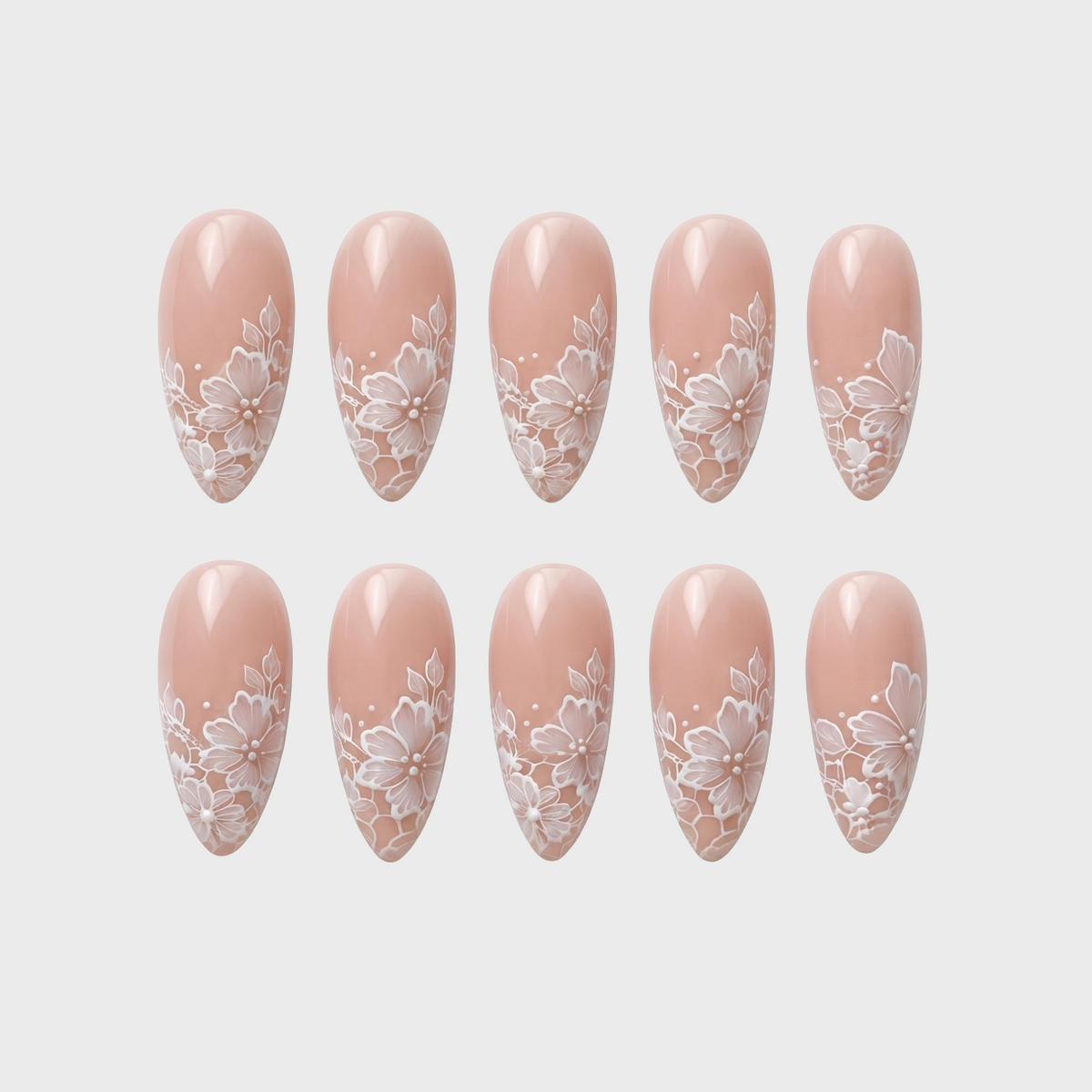 Nude press-on nails featuring a white floral lace pattern.