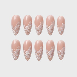 Nude press-on nails featuring a white floral lace pattern.