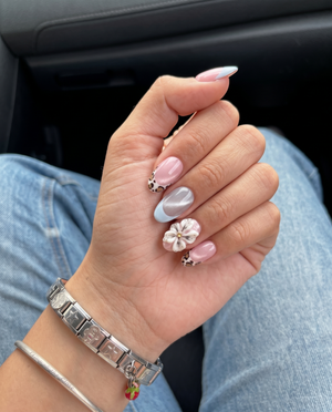 Pink cat-eye press-on nails with blue French tips, leopard print accents, and 3D white flowers.