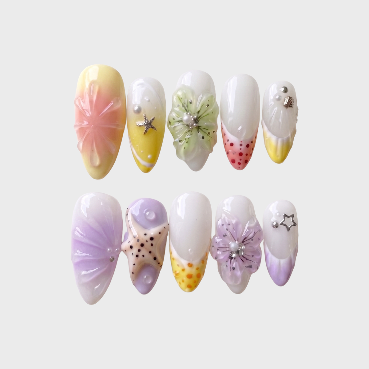 Pastel press-on nails featuring 3D flowers, starfish charms, ocean shells, and pearls.