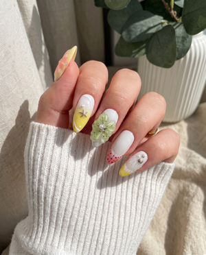 Pastel press-on nails featuring 3D flowers, starfish charms, ocean shells, and pearls.