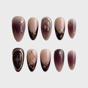 Celestial burgundy French press-on nails with gold star and constellation designs.
