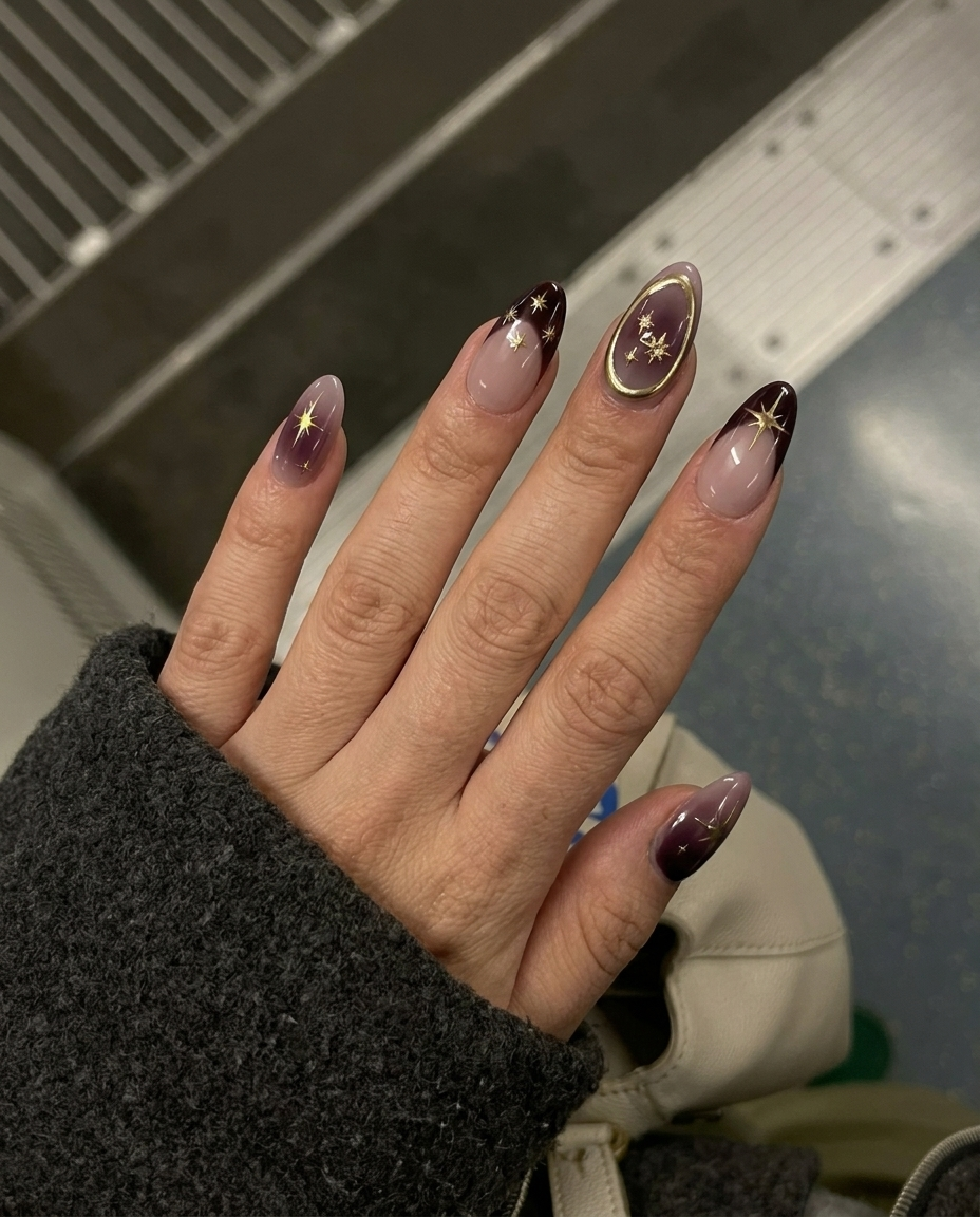Celestial burgundy French press-on nails with gold star and constellation designs.