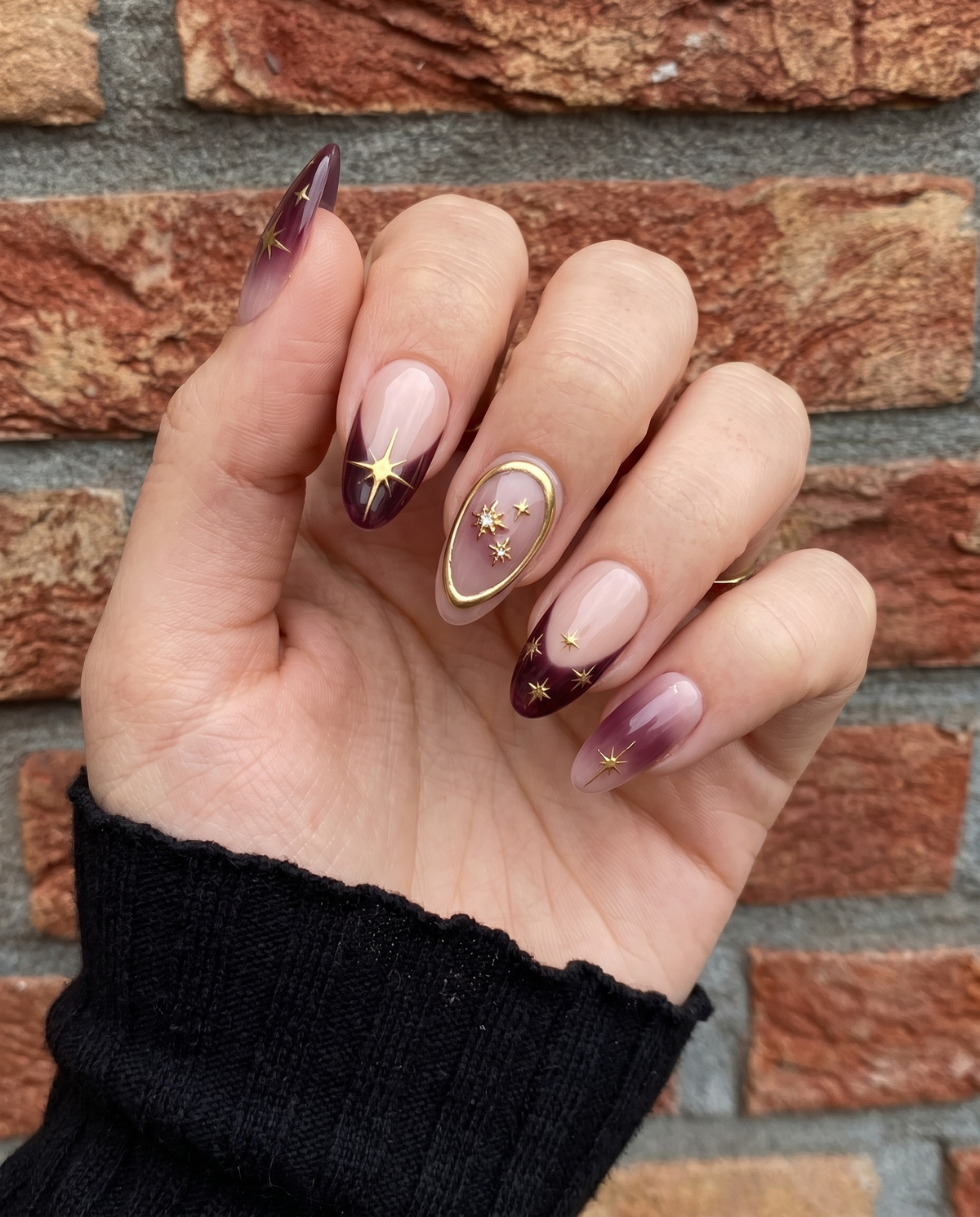 Celestial burgundy French press-on nails with gold star and constellation designs.