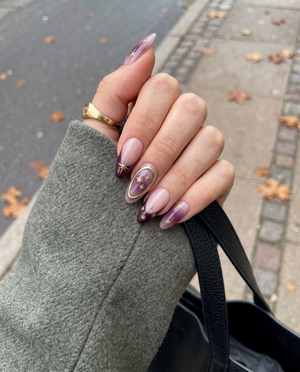 Celestial burgundy French press-on nails with gold star and constellation designs.
