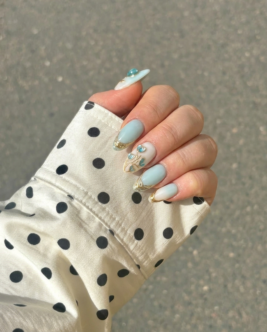 Mint blue and milky white ombré press-on nails with 3D heart-shaped floral details and metallic gold accents.