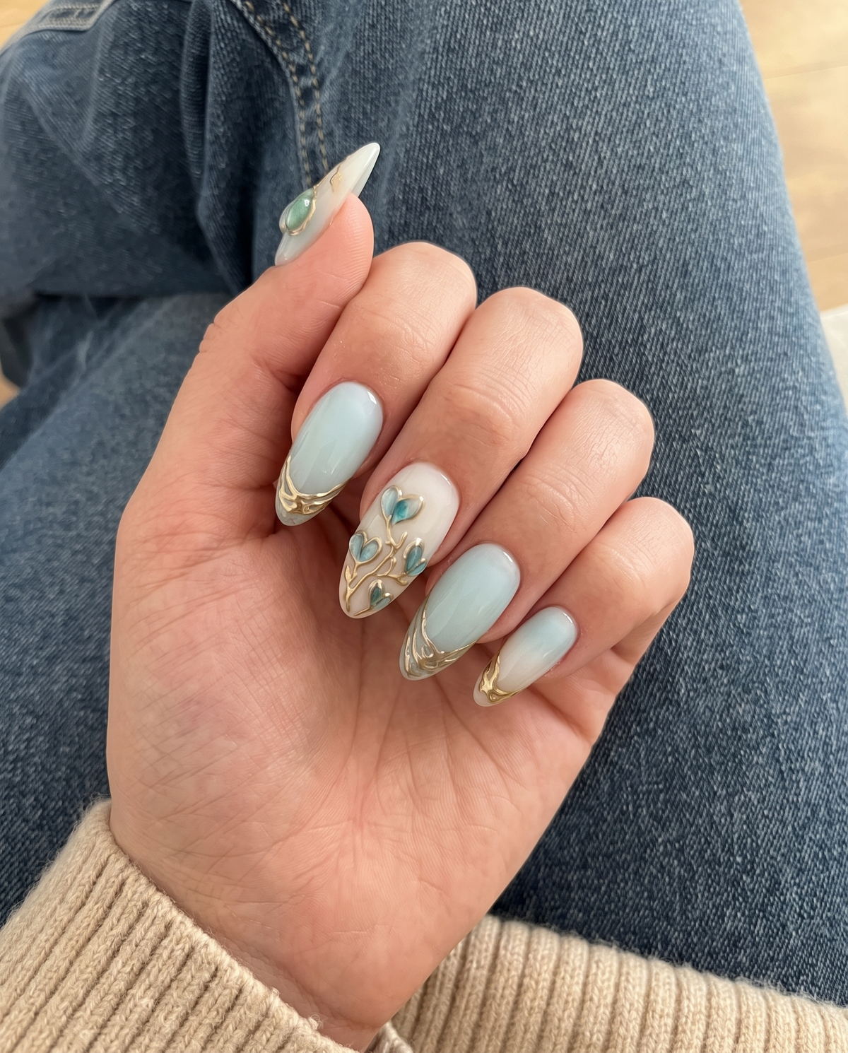 Mint blue and milky white ombr������������ press-on nails with 3D heart-shaped floral details and metallic gold accents.