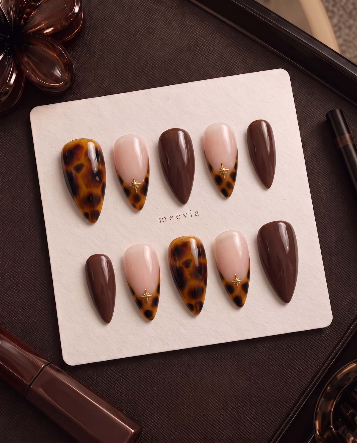 Amber tortoiseshell, chocolate brown, and nude pink star press-on nails