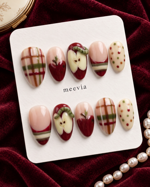 Apple-themed press-on nails with red apples, plaid stripes, cream accents, and colorful dots