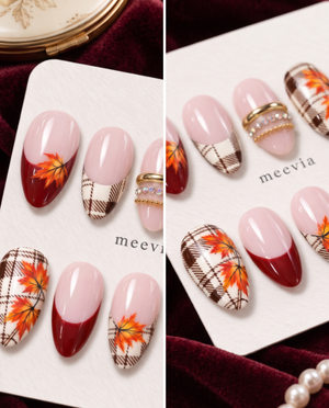 Pink and burgundy press-on nails with brown plaid, orange maple leaves, and gold accents