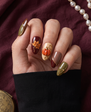Autumn pumpkin and maple leaf press-on nails in glossy olive, burgundy, brown, mauve, and cream tones with gold accents