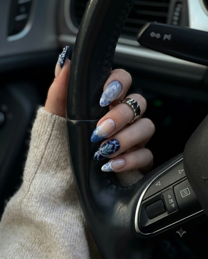 A set of blue and white porcelain-style press-on nails featuring floral patterns, marble designs, and silver accents.