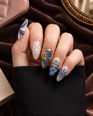 Blue and gold chrome snowflake press-on nails with glitter and rhinestone details